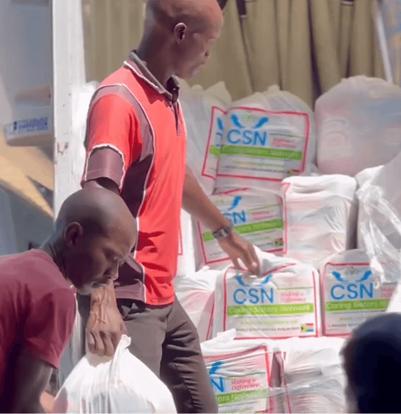 Image of two people handing out aid packs